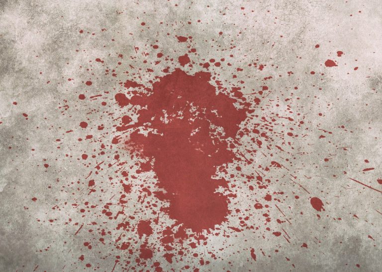 a red paint splattered on a concrete surface.