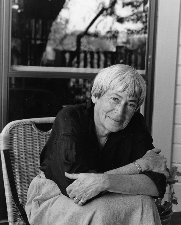 a black and white photo of a woman sitting on a chair.