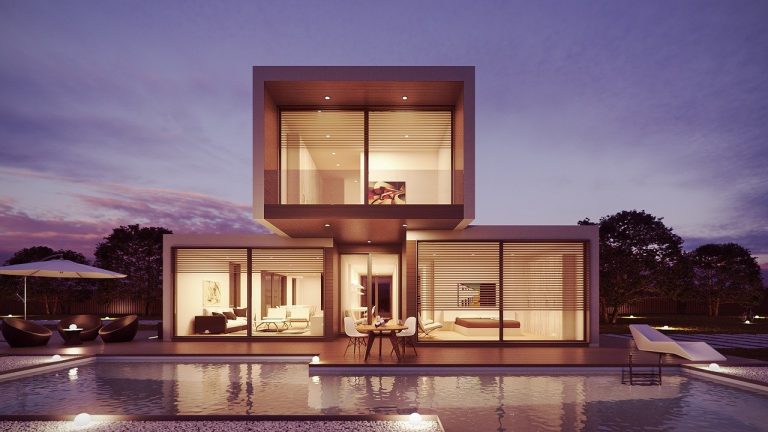 a modern house with a pool at night.