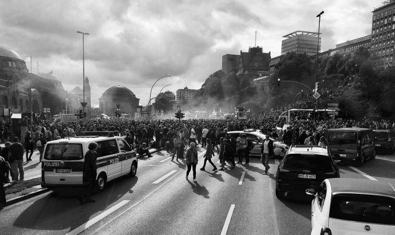 a black and white photo of a crowd of people on a street.
