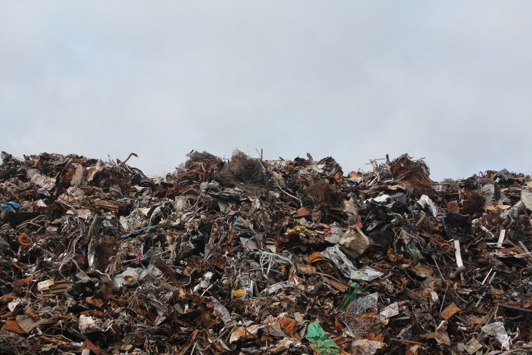 a large pile of trash sitting on top of a field.