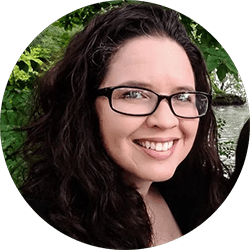 a woman with glasses is smiling for a picture.