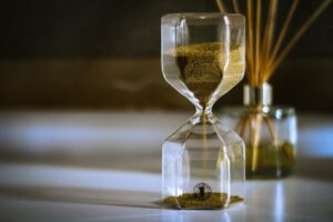 an hourglass with sand in it and reeds in the background.