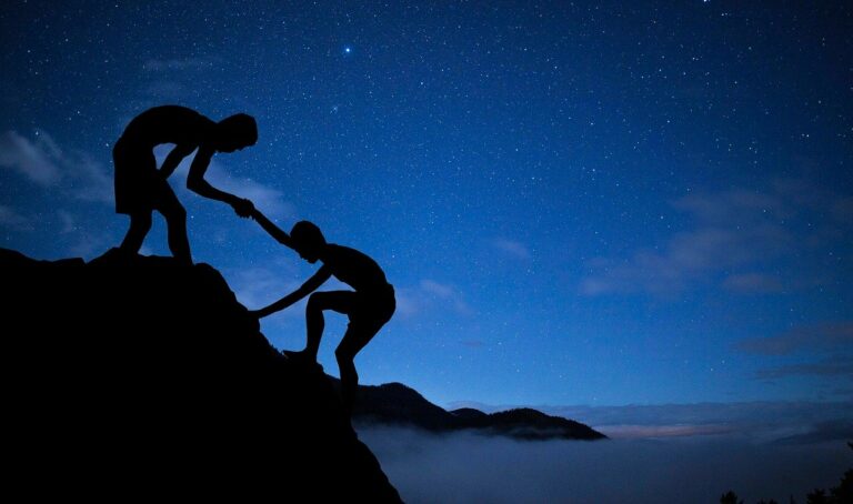 a couple of people standing on top of a mountain.