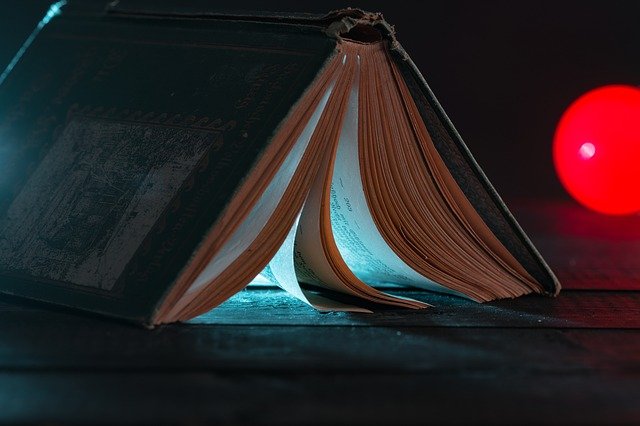 an open book sitting on top of a wooden table.